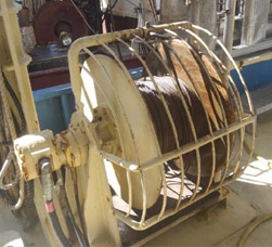 Example of a traditional wire rope winch fitted with a guard to prevent entanglement