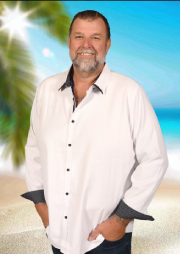 Brendon Stevens Brendon Stevens in a white shirt with black cuffs standing in front of a tropical background.