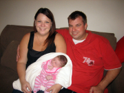 Brendon Stevens Brendon Stevens sitting on a couch with a woman who is holding an infant in her arms.